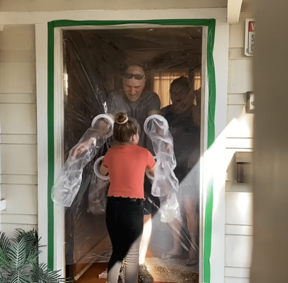 ideiasnutritivas.com - Menina cria uma cortina de pl&aacute;stico para poder abra&ccedil;ar av&oacute;s na quarentena