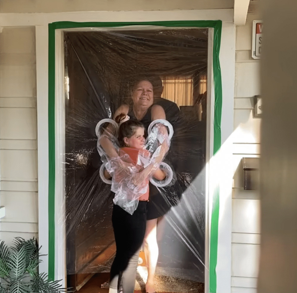 ideiasnutritivas.com - Menina cria uma cortina de pl&aacute;stico para poder abra&ccedil;ar av&oacute;s na quarentena