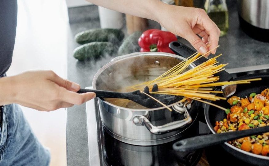 young woman cooking fresh spaghetti pasta at home with vegetables scaled e1612465360543 - 10 erros comuns que as pessoas cometem ao fazer macarrão